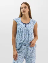 Pijama compuesto por remera sin mangas con escote redondo, botones frontales y detalle de puntilla, acompañado de un pantalón capri con cintura elástica. Presenta un estampado floral en tonos rosados sobre base gris.