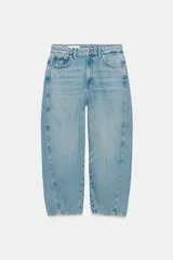 Jeans de tiro medio con diseño de volumen crop y perneras curvas. Presenta cinco bolsillos, cierre frontal con cremallera y botón metálico.