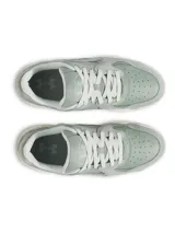 Championes Under Armour modelo Court Anatomix, color verde menta con detalles en blanco. Presentan una parte superior que combina gamuza y materiales sintéticos, con una entresuela de EVA acolchada y suela de goma gruesa.