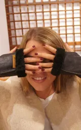 Guantes de cuero color azul marino con interior y bordes de piel sintética negra. Presentan una etiqueta de marca en cuero color suela.