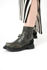 Botas de cuero negro con elásticos laterales, detalle de gamuza en el talón y suela de goma con plataforma.