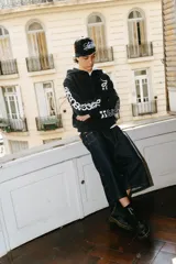 Hoodie negro con cierre, corte regular y lavado gastado. Estampado con logo en el pecho y diseños en las mangas.