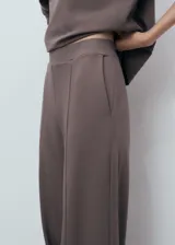 Pantalón de corte recto y largo, color marrón, con cintura elástica sin cierre y bolsillos laterales.
