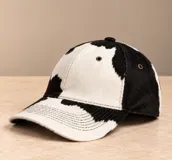 Gorro tipo visera de cuero color marrón, con ojales metálicos de ventilación y costuras pespunteadas en la visera.