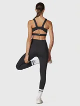 Calza negra de tiro alto con largo hasta el tobillo, confeccionada con una mezcla de poliéster y spandex, y tratada con aloe vera para mayor suavidad.