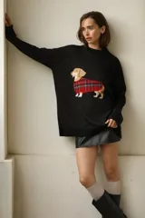 Sweater negro de tejido de algodón con cuello redondo y corte oversize. Presenta un diseño de perro salchicha con una capa escocesa.