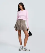 Short pollera de sastrería color marrón con estampa a cuadros, diseño plisado y cintura con pasadores. Combina la comodidad de un short con la estética de una minifalda.