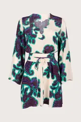 Kaftán largo con estampado floral en tonos verde, morado y blanco. Tiene escote en V, mangas largas y corte holgado.