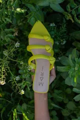 Sandalias de cuero color amarillo flúor con tres tiras finas con nudo y punta fina.