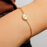 Pulsera dorada con cadena de eslabones y dije ovalado con el símbolo de Géminis.