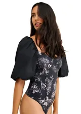 Body negro con estampado de estilo toile de jouy en blanco, mangas abullonadas cortas y escote cuadrado.