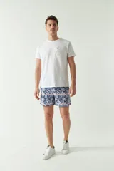 Short de baño con estampado tropical en tonos azules y rosados, confeccionado en tela ligera de secado rápido. Cuenta con cintura elástica con cordón ajustable, dos bolsillos laterales, un bolsillo trasero y logo bordado.