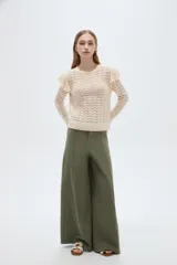 Sweater de algodón color natural, de punto con diseño calado, cuello redondo a la base y mangas largas con volados en los hombros.