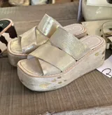 Sandalias con plataforma color dorado, con tiras cruzadas sobre el empeine y suela de goma.