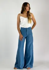 Pantalón de lino color azul, de corte palazzo, tiro alto y bolsillos frontales.