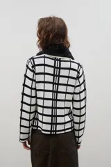 Saco de punto con diseño de cuadros, cierre frontal con botones y cuello de pelo sintético desmontable.