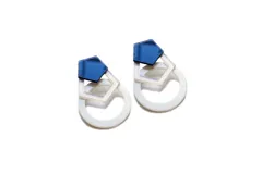 Par de aros colgantes con forma geométrica, con un hexágono azul espejado en la parte superior, un cuadrado calado blanco en el medio y un círculo blanco en la parte inferior.
