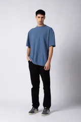 Remera de corte oversized en color marrón, confeccionada en tejido de algodón con textura de micropanal. Presenta cuello redondo con detalle de costura en forma de X y mangas cortas de estilo caído.