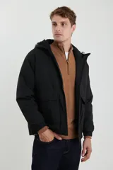 Campera impermeable negra con capucha, cierres a tono y cursores negros metalizados, bolsillos frontales con tapa, elásticos regulables en el ruedo e interior térmico con detalles confeccionados con láser.