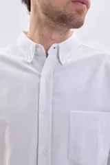 Camisa de manga larga oxford en color blanco, con cuello abotonado y bolsillo frontal en el pecho.