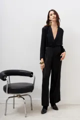 Pantalón de corte palazzo color negro, íntegramente bordado con lentejuelas y mostacillas. Presenta tiro medio, largo al piso y cierre invisible en el lateral.