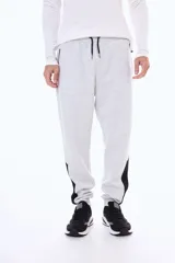 Pantalon de jogging de felpa en color gris melange, con cintura elástica ajustable mediante cordones, puños en los tobillos y paneles laterales en contraste de color negro en la parte inferior de las piernas.
