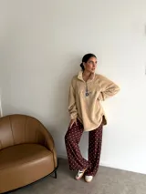 Pantalón de corte recto y holgado, confeccionado en lanilla color marrón oscuro con estampado de lunares blancos. Presenta cintura elástica para mayor comodidad.