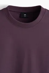 Remera boxy de algodón en punto liviano color bordó, de hombros caídos, cuello redondo ribeteado acanalado y corte oversized.
