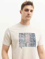 Remera color petróleo de manga corta con estampa de un edificio y texto en el frente.