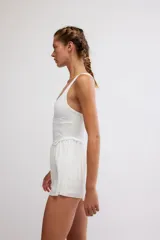 Vestido corto deportivo negro con efecto smock en el torso, tirantes finos blancos y falda de vuelo suave.