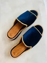 Sandalias de terciopelo azul marino con ribete dorado y plantilla de cuero tostado, de diseño abierto en la punta.