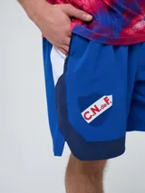 Bermuda deportiva Umbro del Club Nacional de Football, modelo Pro Training, de color azul marino con detalles blancos en el dobladillo. Presenta el escudo del club en una pierna y el logo de la marca en la otra.