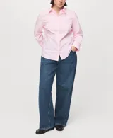 Camisa entallada de popelín de algodón color rosado, con cuello camisero, manga larga y cierre frontal oculto con botones bajo tapeta.