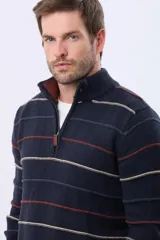 Buzo de algodón tejido color azul marino con rayas horizontales en beige y bordó. Presenta cuello alto con medio cierre frontal y puños y dobladillo acanalados.