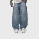 Pantalón de jean con corte ultra baggy, de tiro medio y diseño holgado en toda la pierna. Presenta un lavado clásico azul medio con efecto desgastado.