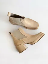 Botas tipo chelsea de cuero color visón, con plataforma, taco cuadrado y punta cuadrada.