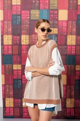 Chaleco de punto color beige con rayas verticales marrones y cuello redondo.