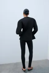 Leggings negros de tiro alto con bolsillos falsos de vivo en el delantero y cierre lateral con cremallera oculta. Presentan cremalleras ocultas en los bajos.