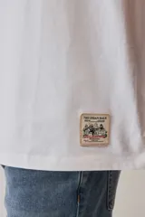 Remera marrón de manga corta, con cuello redondo y diseño holgado.