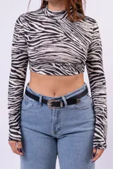 Polera de cuello alto y manga larga con estampado animal print de leopardo, confeccionada en tejido elástico ajustado al cuerpo.