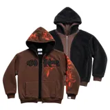 Campera reversible con cierre frontal. Un lado confeccionado en algodón color marrón con estampa plastisol en color naranja, bordados con apliques y capucha. El otro lado confeccionado en tela polar de pelo largo color negro con capucha.