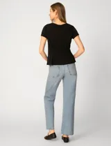 Remera blanca de manga corta con cuello redondo, confeccionada en una mezcla de modal, poliéster y elastano. Presenta un diseño con alforzas verticales en el frente que aportan estructura y una silueta relajada.