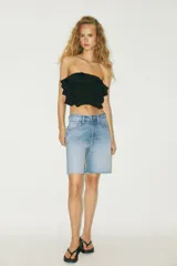 Top bandeau color crema con escote recto, hombros descubiertos y detalle de volantes en capas.