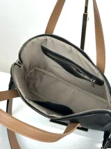 Cartera negra de cuero genuino con correa corta de cuero color tostado y correa larga de cinta negra con letras blancas.