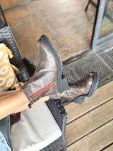 Botas cortas de cuero color chocolate, con elástico lateral, cierre interno con cremallera roja, pespuntes rojos y suela track.