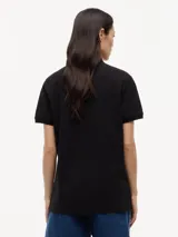 Chomba de algodón elástico con cuello polo y cartera de tres botones. Presenta un diseño de corte regular con cuello y puños de punto canalé, destacando por el logo colaborativo de Tommy Hilfiger y Cadillac Formula 1 en el pecho.