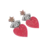 Par de aros colgantes con forma de corazón fucsia con glitter, unidos a un dije con forma de ojo plateado con glitter y una estrella dorada.