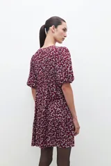 Vestido midi de color bordó con estampado floral blanco, mangas cortas abullonadas y falda con volantes.