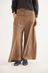 Pantalón de corte ancho y tiro alto, color tostado, con cierre frontal de tres botones y pinzas en la cintura.
