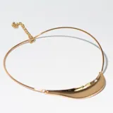 Gargantilla dorada rígida con cadena de ajuste y aplique curvo en el frente.